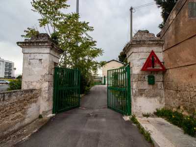 Tramite un cancello verde situato tra due colonne in pietra, entriamo nel cortile della casa, dove incontriamo il 40enne figlio della signora che abita all'interno della struttura